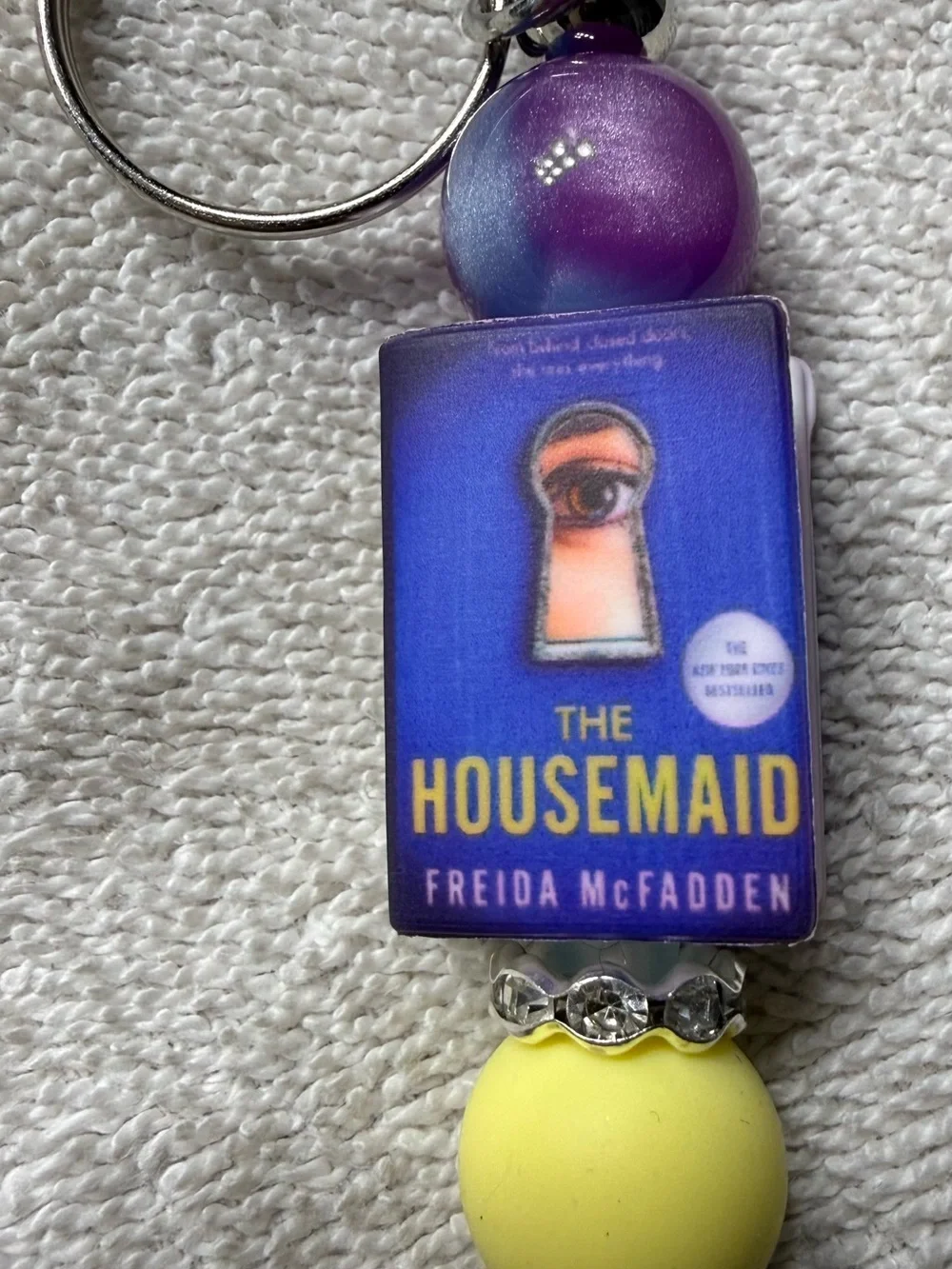 The Housemaid Book Cover Keychain in Purple & Yellow